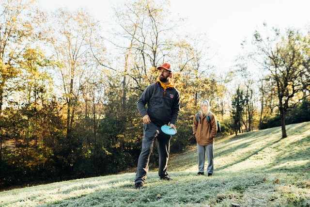 Two men playing disc golf on a hill