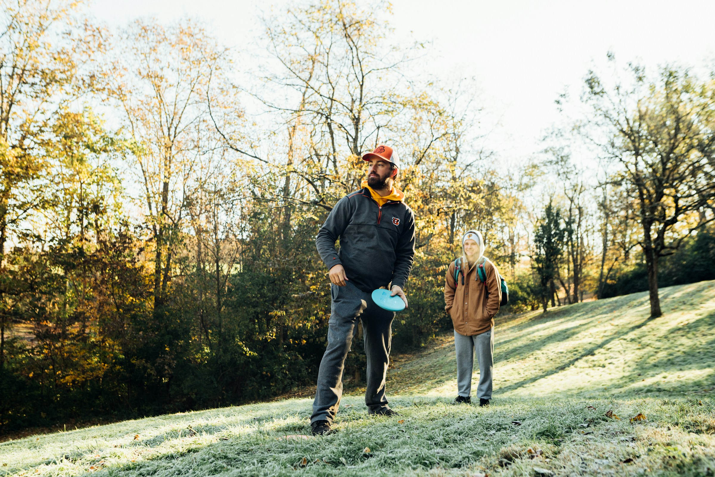 Two men playing disc golf on a hill