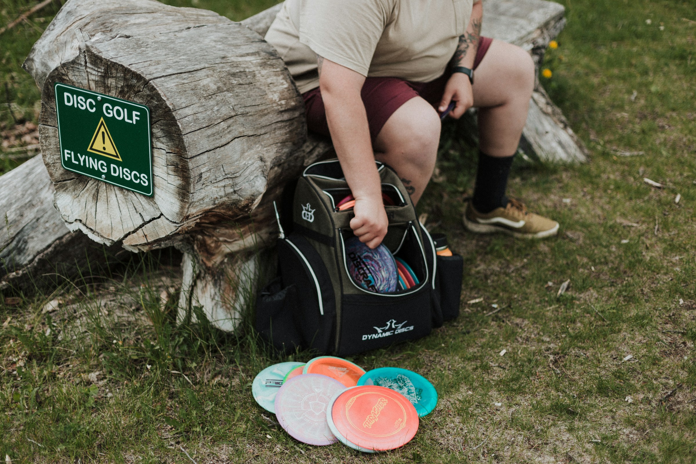 A man sifting through his disc golf bag